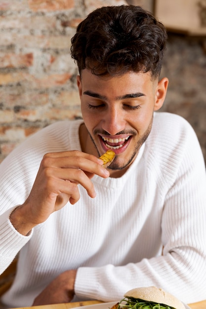 Free Photo medium shot man eating potato