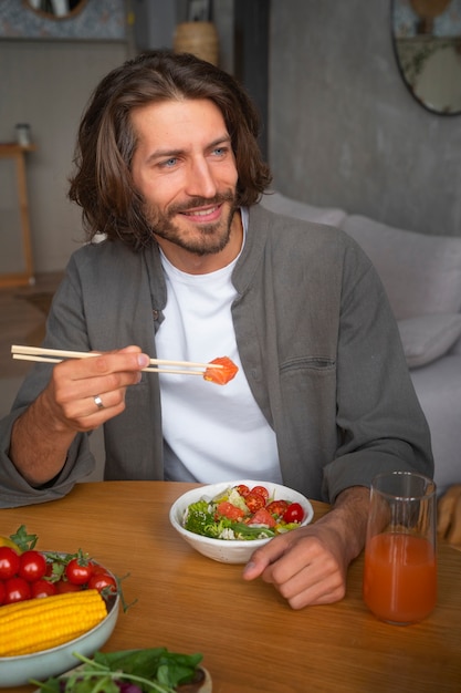 Medium shot man eating salmon bowl