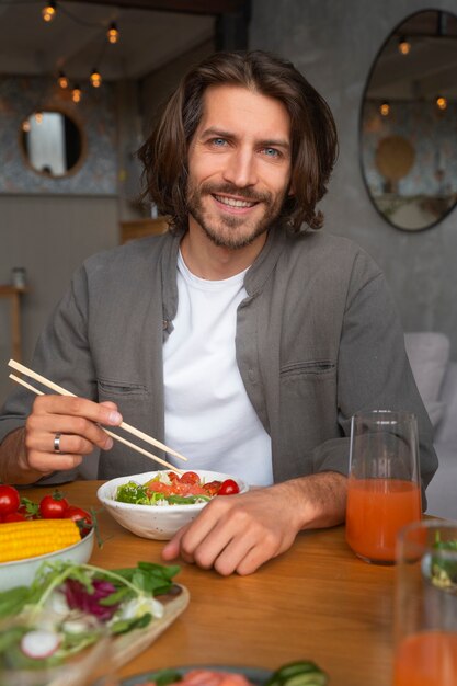 Medium shot man eating salmon bowl