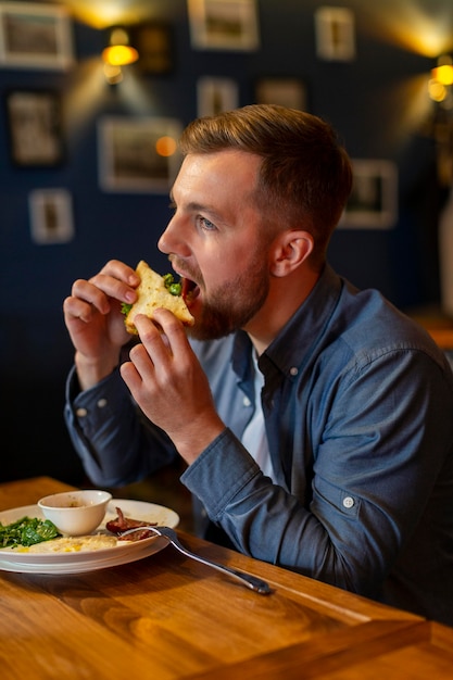 Medium shot man eating sandwich