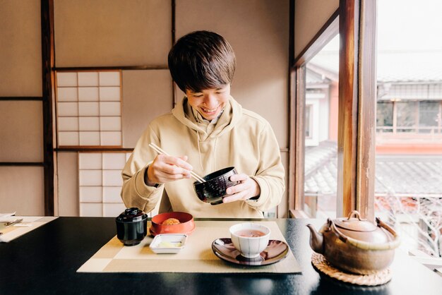 Medium shot man eating with chopsticks