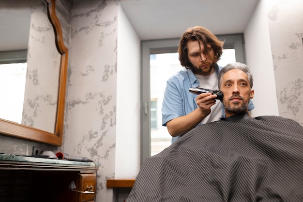 Medium shot man getting a haircut