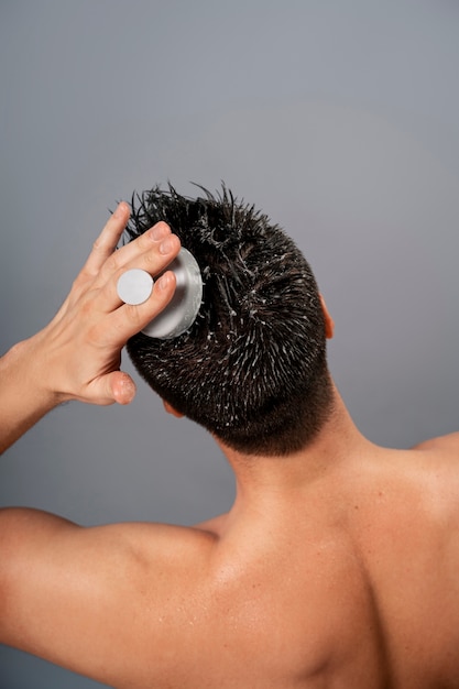 Medium shot man giving himself scalp massage