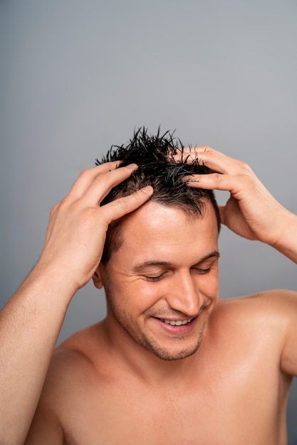 Medium shot man giving himself scalp massage