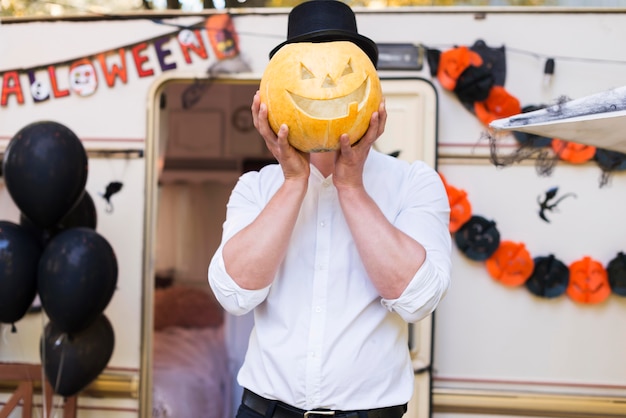 Free Photo medium shot man holding carved pumpkin