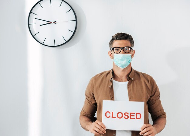 Medium shot man holding closed sign