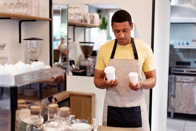 Medium shot man holding coffee cups