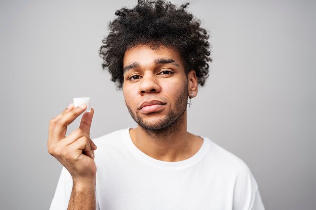 Medium shot man holding cream container