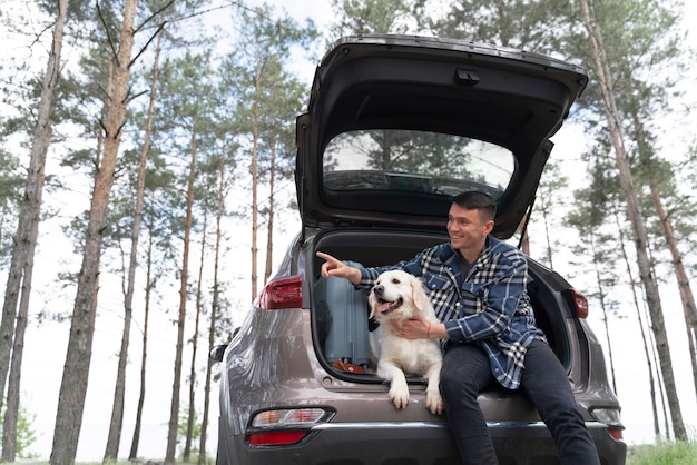 Free Photo medium shot man holding dog in trunk