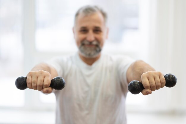 Medium shot man holding dumbbells