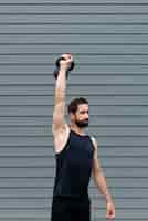 Free photo medium shot man holding kettle bell