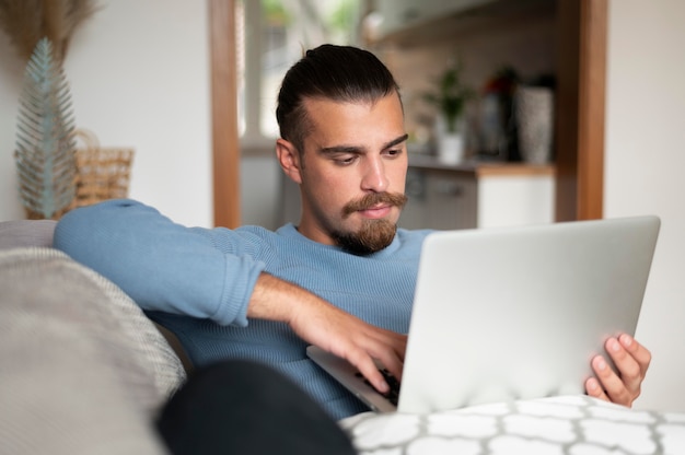 Medium shot man holding laptop