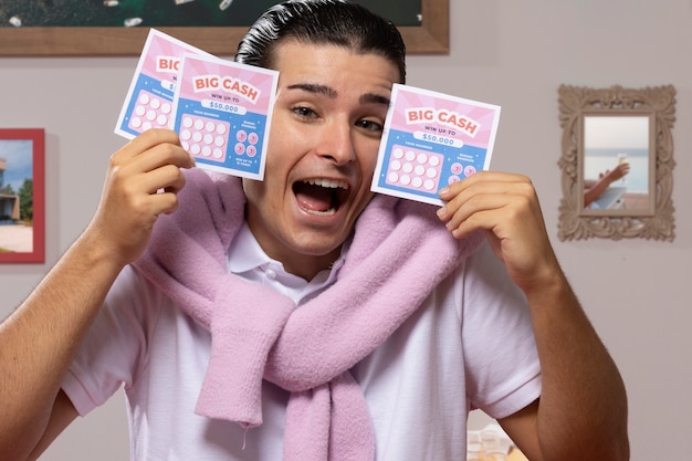 Free photo medium shot man holding lottery tickets