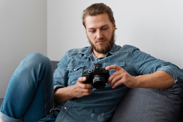 Medium shot man holding photo camera