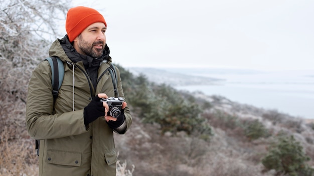 Medium shot man holding photo camera