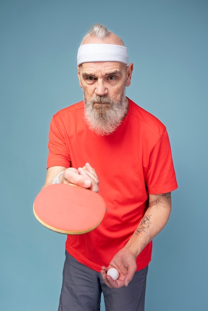 Free photo medium shot man holding ping pong palette