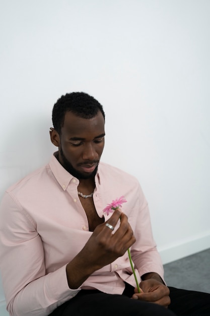 Medium shot man holding pink flower