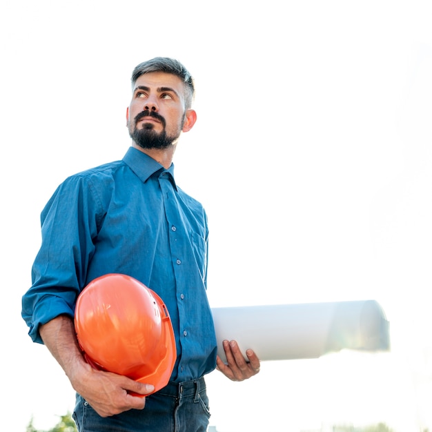 Medium shot of man holding schematics