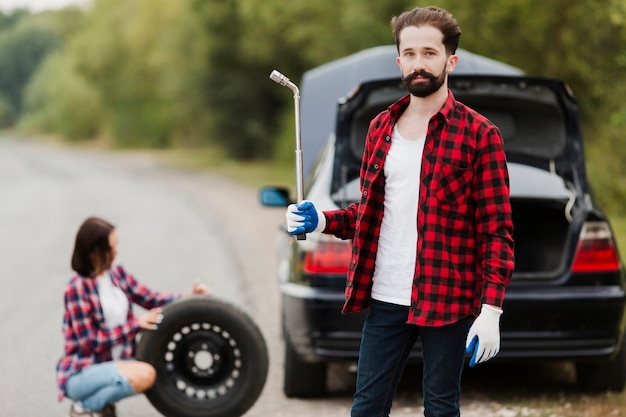 Free Photo medium shot of man holding tyre wrench