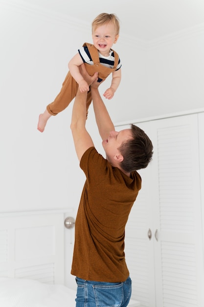 Medium shot man holding up kid