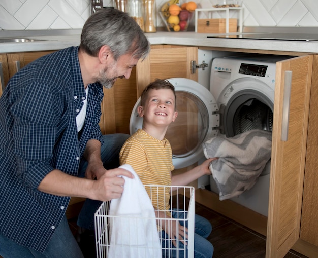 Free photo medium shot man and kid doing laundry