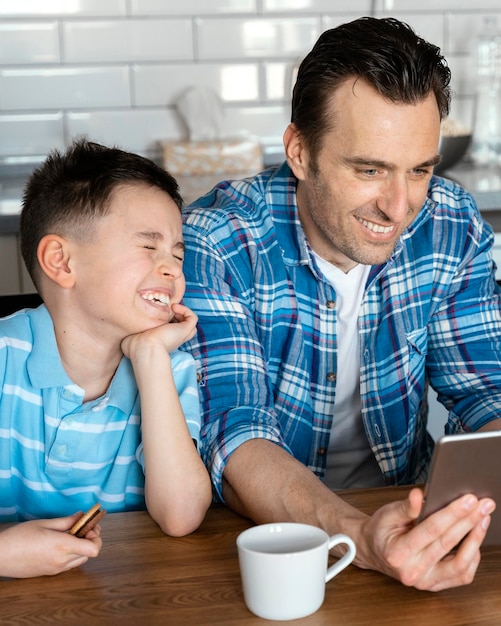 Medium shot man and kid with tablet