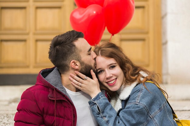 Medium shot of man kissing girlfriend