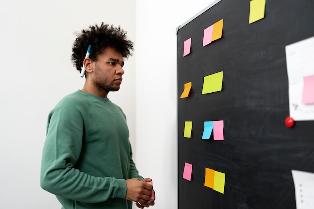 Medium shot man looking at post its