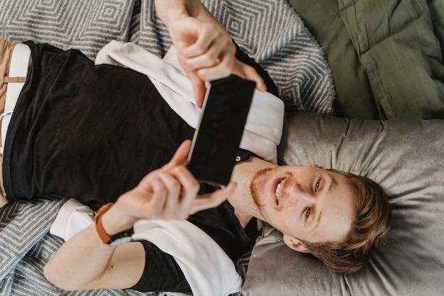 Medium shot man looking at smartphone