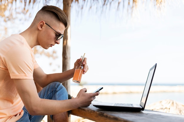 Free photo medium shot man outdoors with laptop