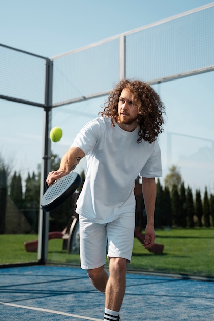 Medium shot man playing paddle tennis