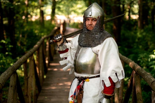 Medium shot man posing as a medieval soldier