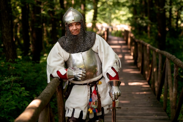 Medium shot man posing as a medieval soldier