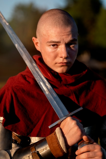 Medium shot man posing as a medieval soldier