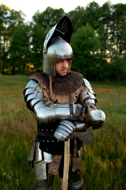 Medium shot man posing as a medieval soldier