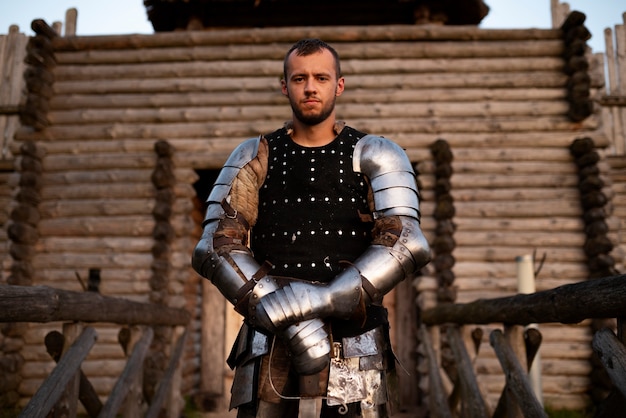 Medium shot man posing as a medieval soldier