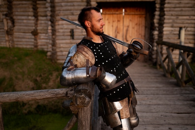 Free photo medium shot man posing as a medieval soldier