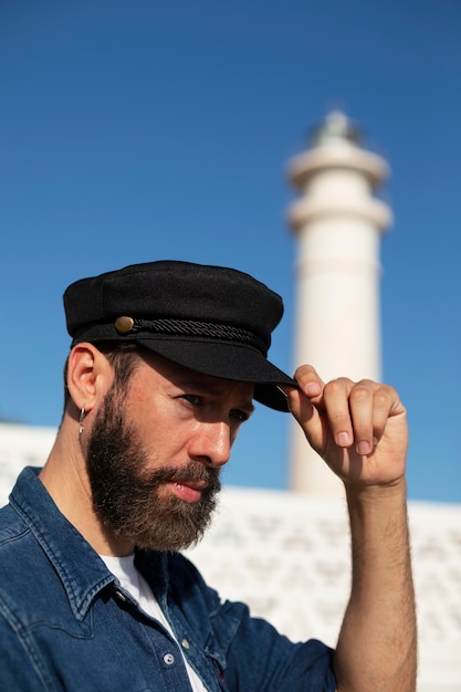 Free photo medium shot man posing at the lighthouse