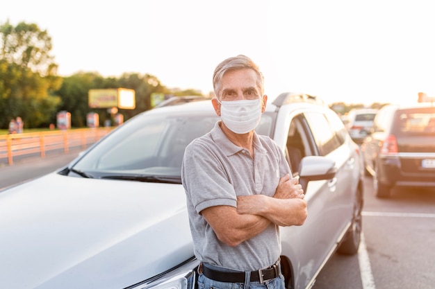 Medium shot man posing near car