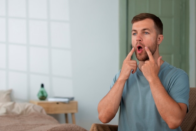 Free photo medium shot man practicing facial yoga