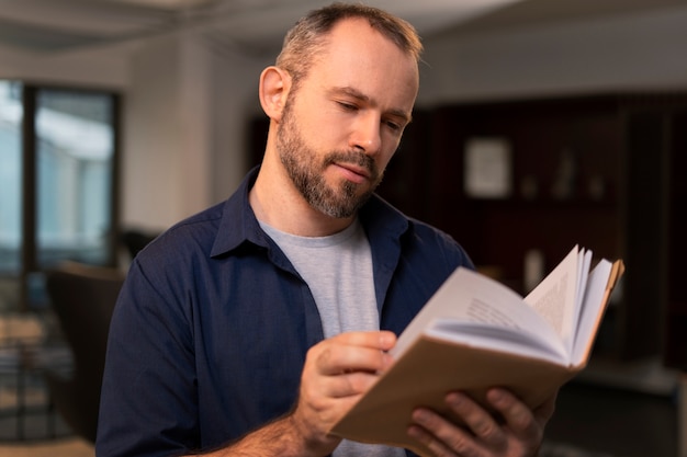 Free photo medium shot man reading indoors