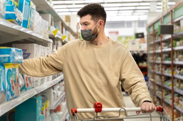 Medium shot man shopping with mask