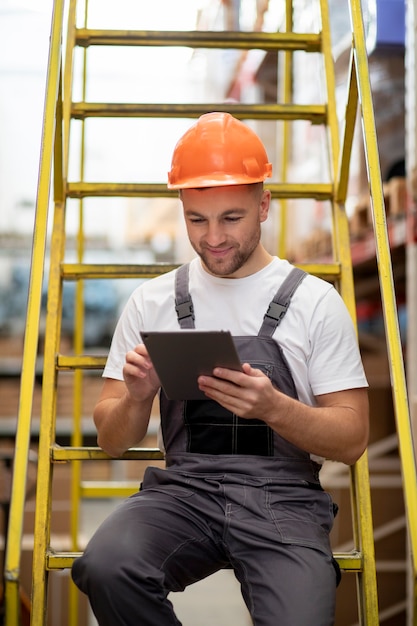 Free photo medium shot man sitting on ladder