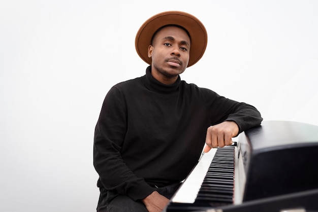 Medium shot man sitting near piano