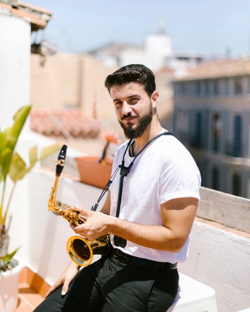 Medium shot man sitting with saxophone