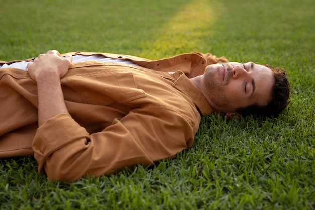 Medium shot man sleeping on grass