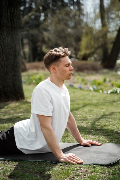 Medium shot man stretching on mat