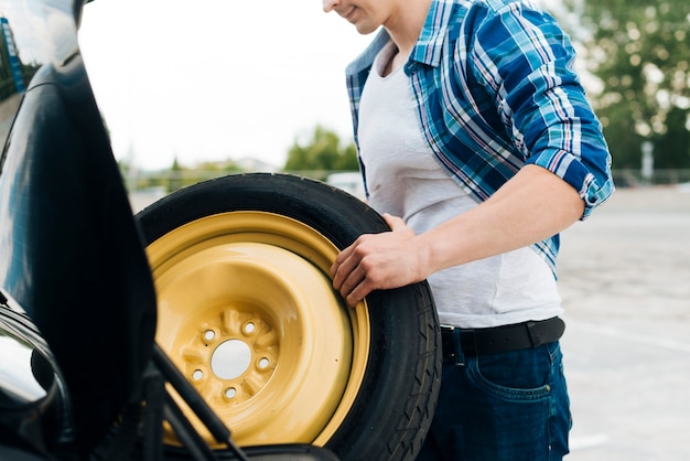 Free Photo medium shot of man taking out spare tire