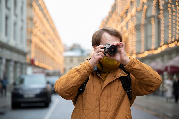 Medium shot man taking photos with camera