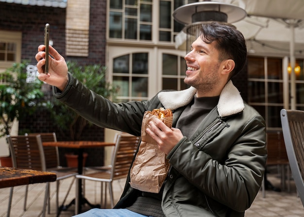 Free photo medium shot man taking selfie